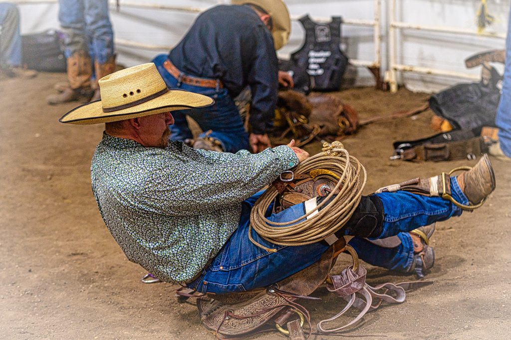 A Bronc Rider stretching in his saddle before his ride