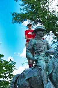 Boy on a statue of Teddy Roosevelt