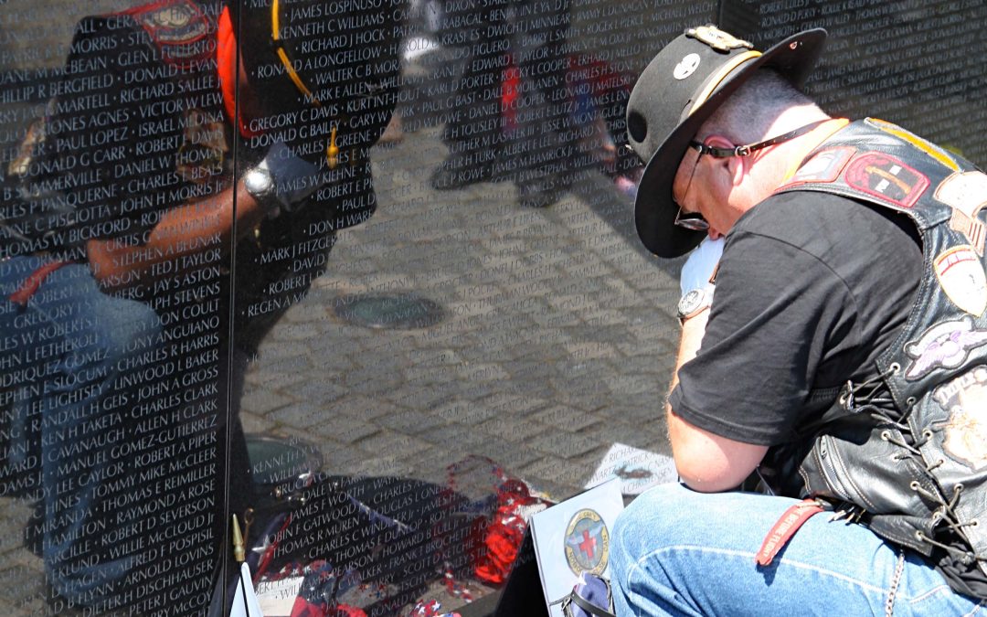Vietnam Veteran laying flag at the Memorial in Washington