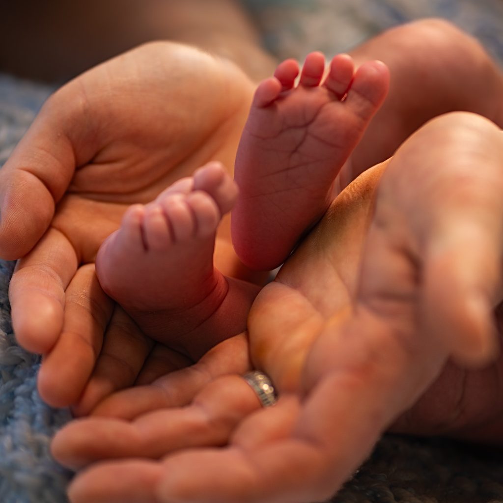 Infants feet in a fathers hands