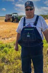 Farmer in overalls in wheat field